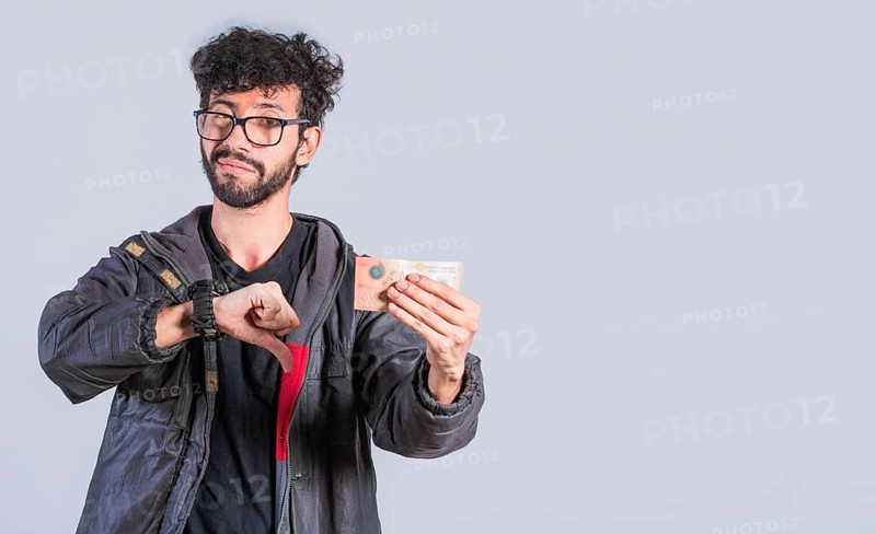 Unhappy person with a Nicaraguan banknote with his thumb down