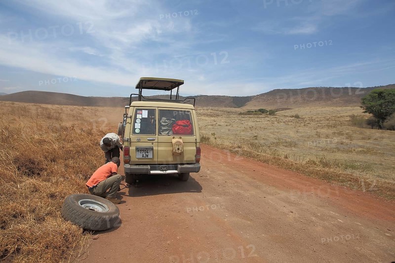 Jeep with spare wheel changing tyre due to car breakdown in Ngorongoro Crater