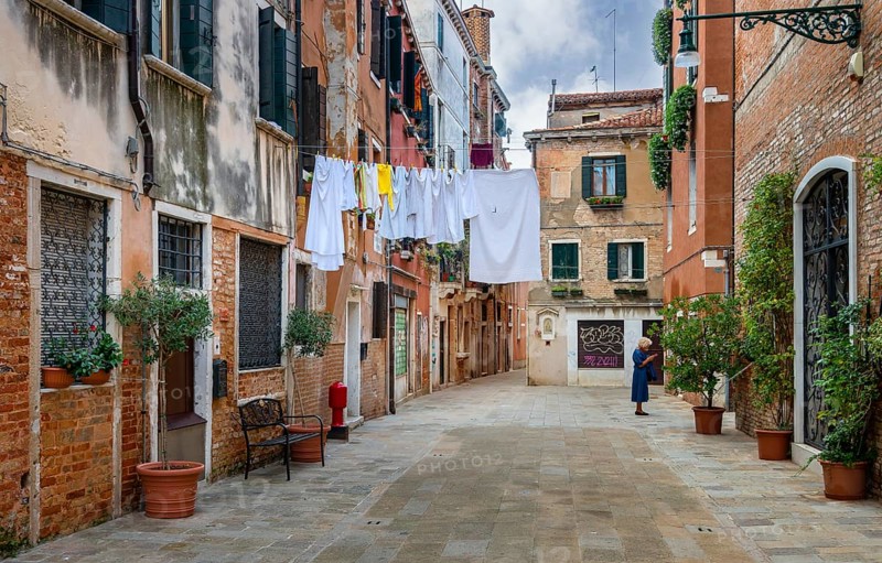 Laundry on a line in front of the typical Venetian house facades in the lagoon city of Venice