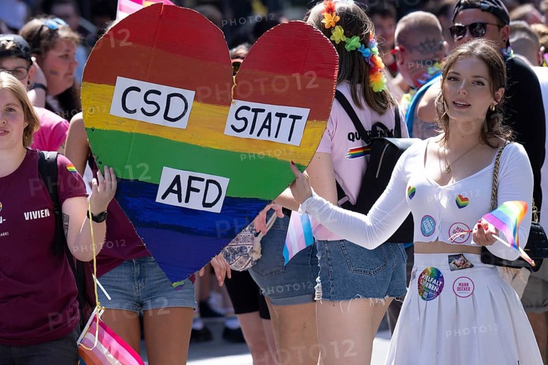 Two homosexual woman carry a heart with the inscription CSD statt AFD at the CSD parade