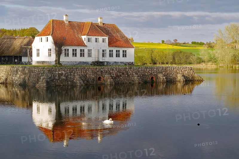 Manor house reflected in the water of a lake