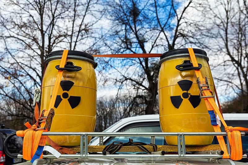 Two yellow metal barrels with signs for radioactivity on roof rack