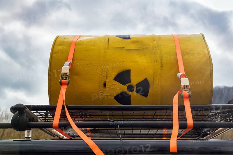 Yellow metal barrel with sign for radioactivity on roof rack