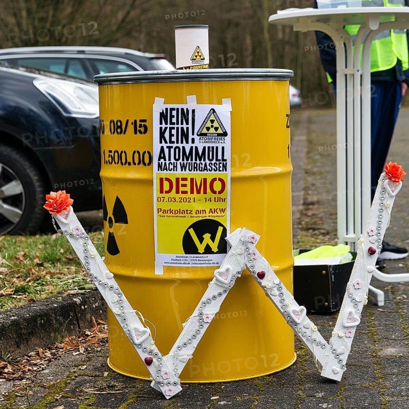 Yellow metal barrel with sign for radioactivity and poster