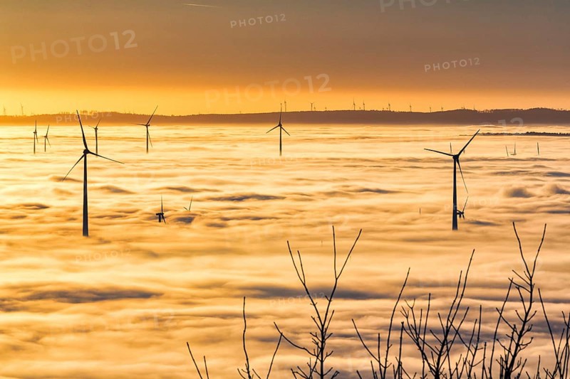 Wind turbines rising from cloud cover
