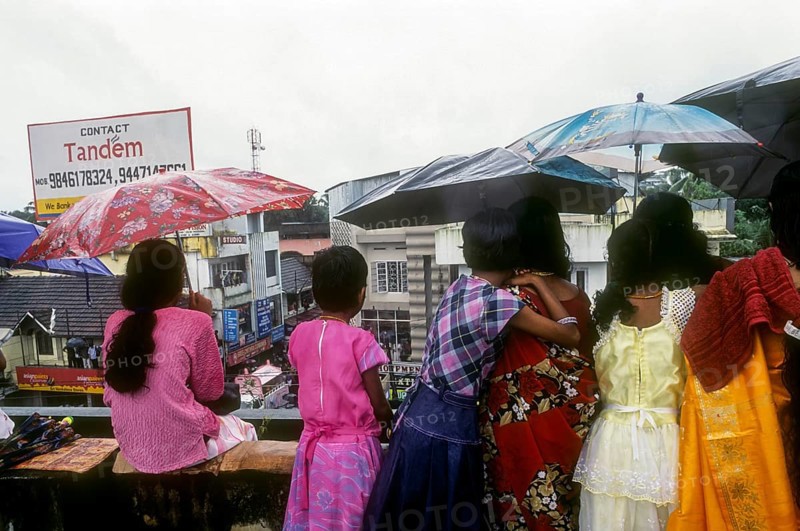 Girls with umbrella admiring Atham festival procession in Tripunithura near Ernakulam