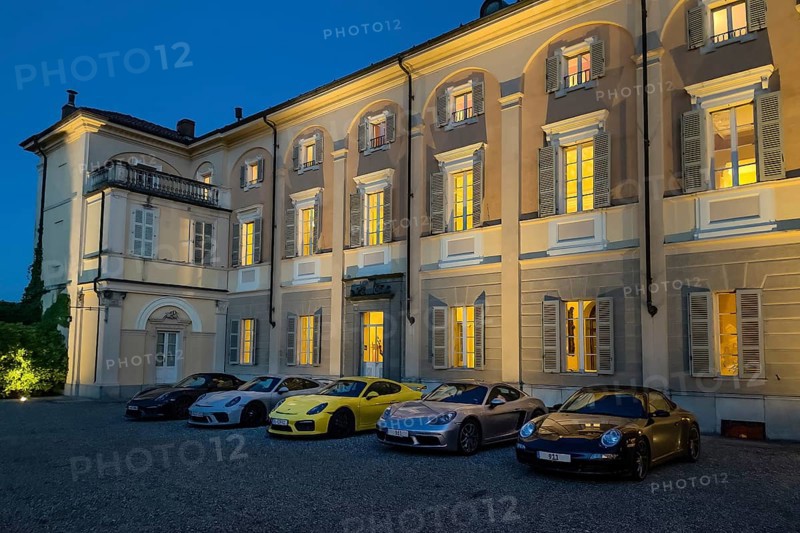 Night shot of five Porsche sports cars in representative courtyard of 18th century Hotel Villa Matilde during blue hour