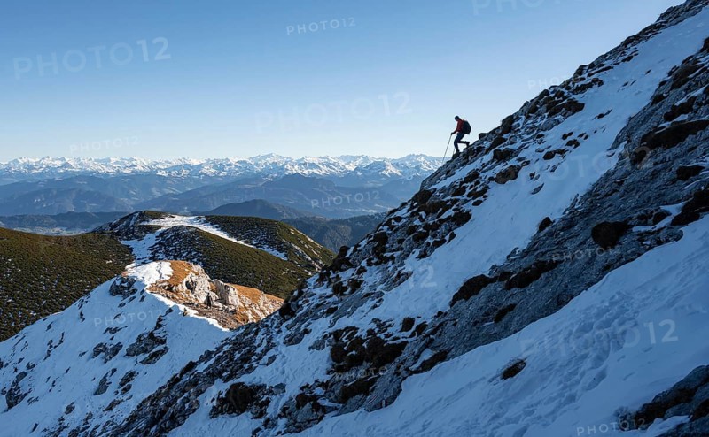 Mountaineers on the rocky summit ridge with the first snow in autumn