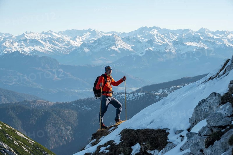Mountaineers on the rocky summit ridge with the first snow in autumn