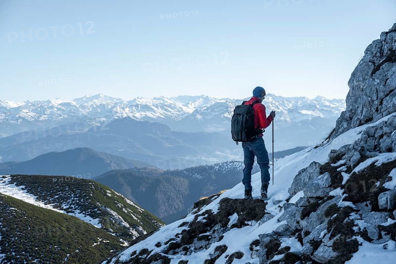 Mountaineers on the rocky summit ridge with the first snow in autumn