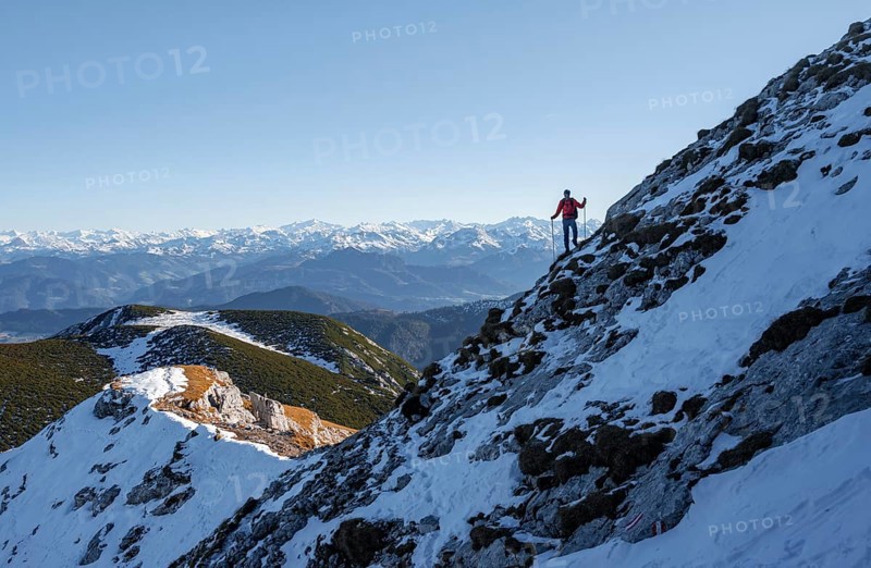 Mountaineers on the rocky summit ridge with the first snow in autumn