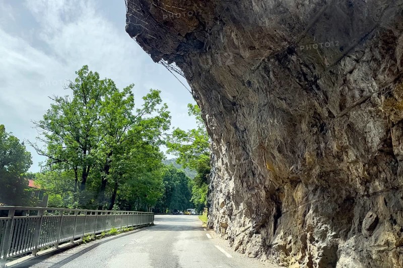Far overhanging rock face over narrow road in gorge Clue de St-Auban with protection against falling rocks