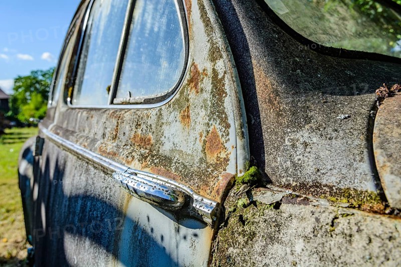 Old car rolled for scrapping in a meadow. Alsace