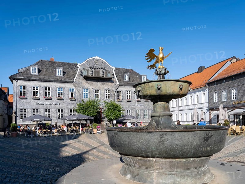 Golden eagle on the market fountain in front of the Kaiserringhaus with slate facade