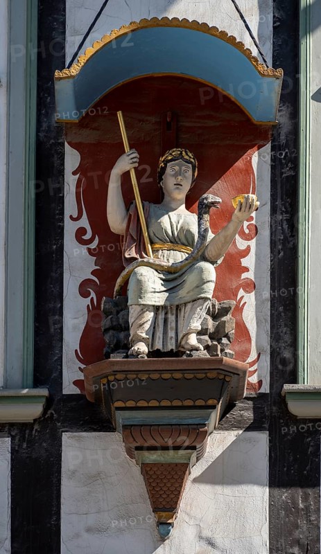 Figure with bowl and staff at the Rats-Apotheke