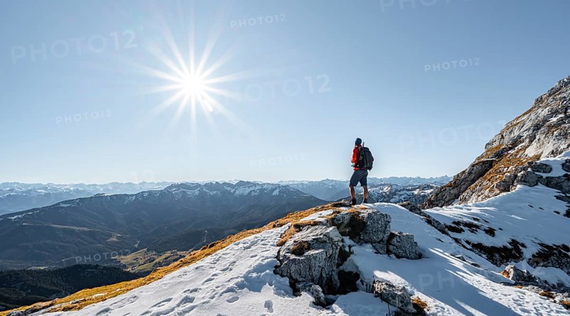 Climbers on the rocky summit ridge with first snow in autumn