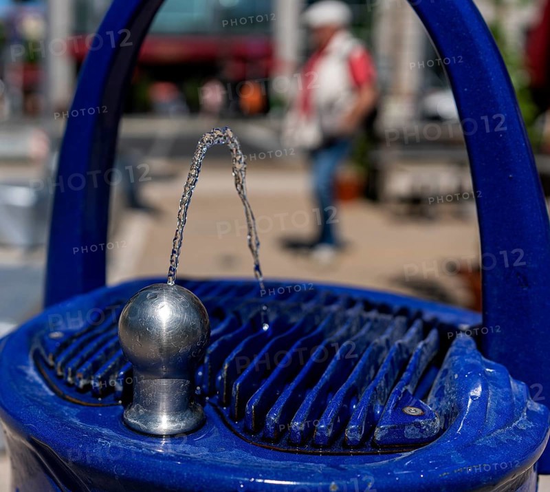 Blue fountain with drinking water dispenser on a public square