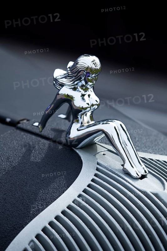 A naked woman as a radiator mascot on a vintage car
