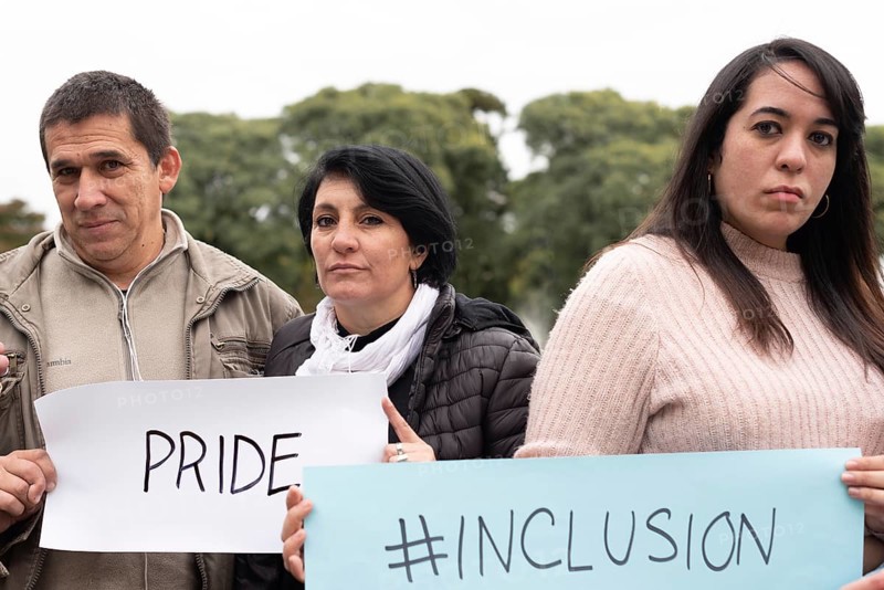 A group of people holding inclusion and pride signs as a protest. LGBT Concept