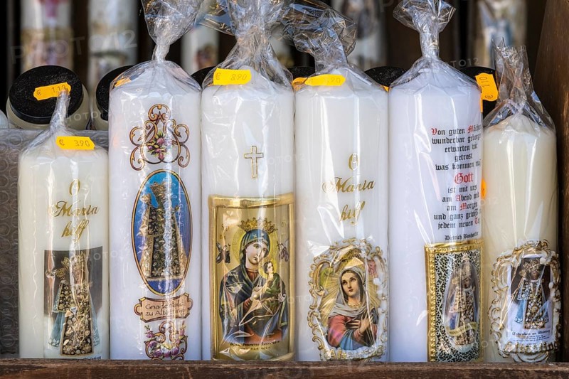 Candles with images of Mary and the saints in front of a devotional shop at Kapellplatz