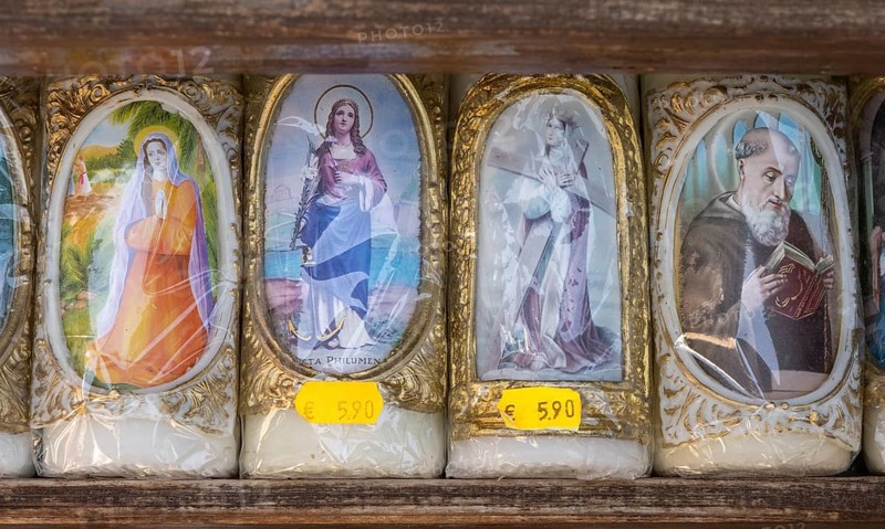 Candles with images of Mary and the saints in front of a devotional shop at Kapellplatz