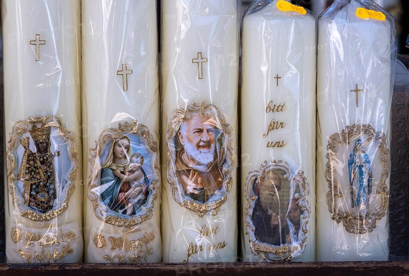 Candles with images of Mary and the saints in front of a devotional shop at Kapellplatz
