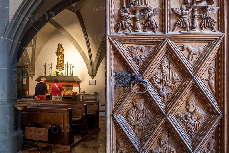 Richly decorated wooden portal with view into the collegiate parish church of St. Philip and St. James