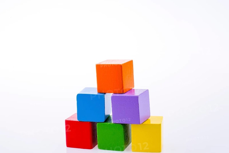 Hand playing with colorful cubes on a white background