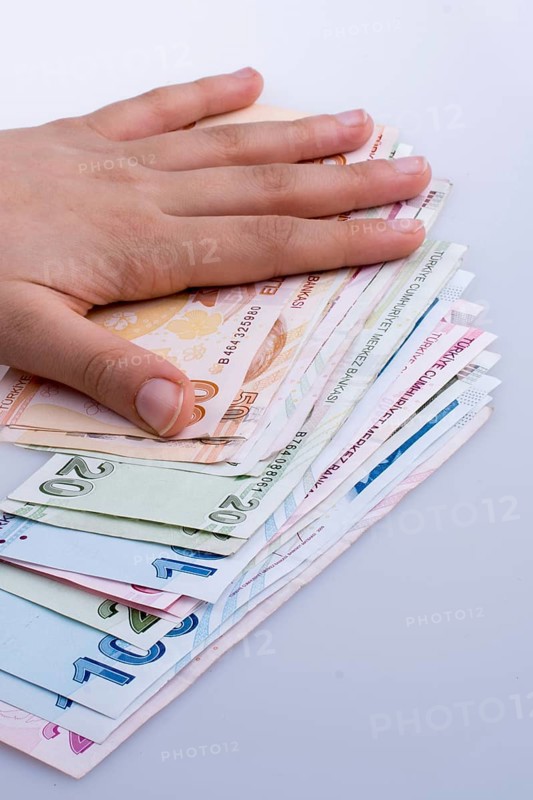 Hand holding Turksh Lira banknotes on white background
