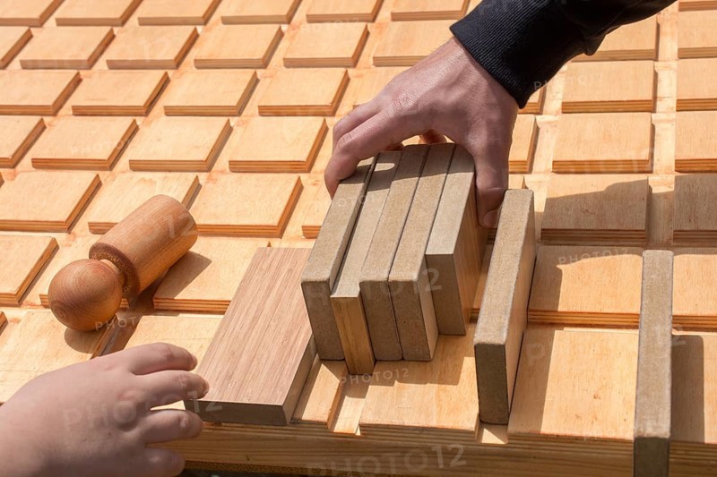 Hand holding wooden puzzle element in hand