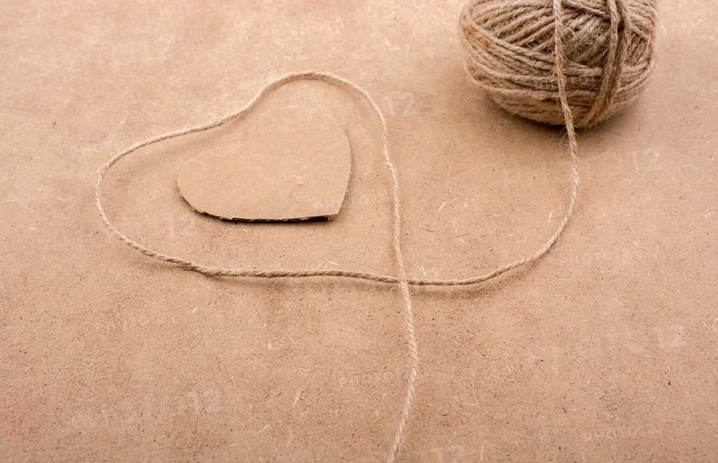 Thread off spool form a heart shape on brown background