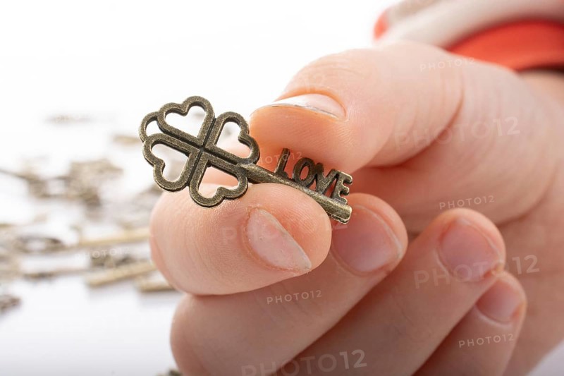 Hand and retro style metal keys on a white background