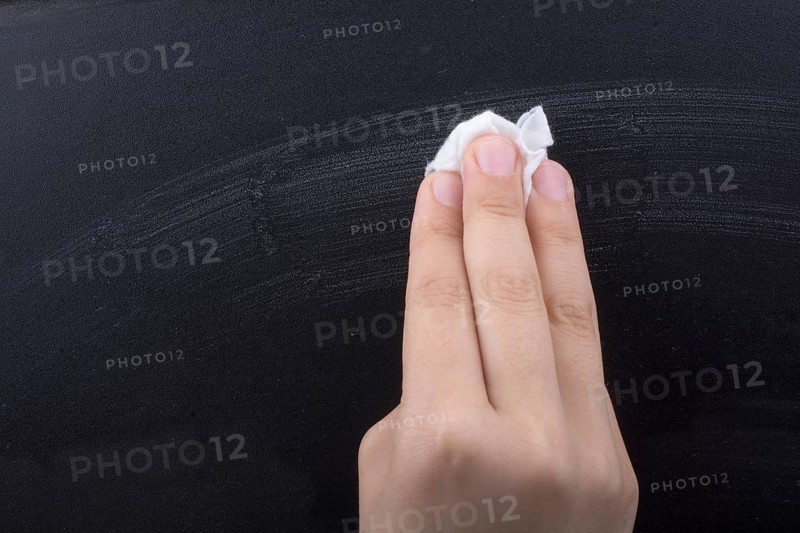 Hand cleaning blackboard on a white background