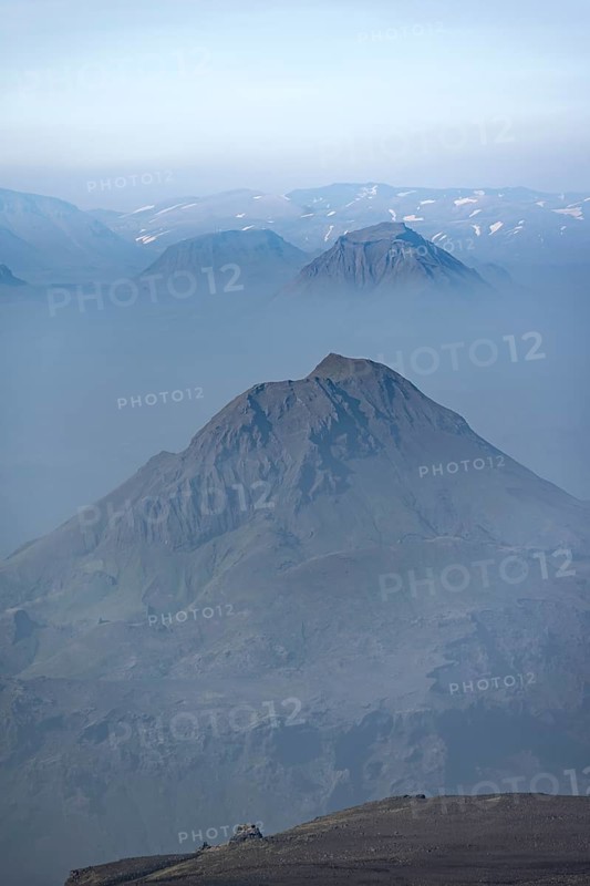 View of mountain peaks between fog