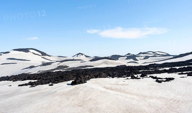 Barren hilly volcanic landscape of snow and volcanic rock