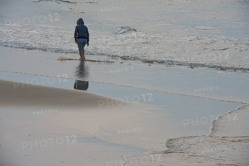 Fisherman walking along the beach