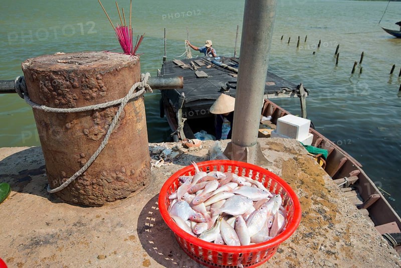Small fishing pier on the Thu Bon River where a fishing boat is unloaded