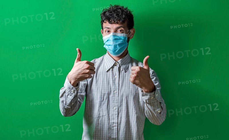Isolated man with mask on giving thumbs up, Person giving thumbs up with mask on isolated. Concept of the correct use of the surgical mask