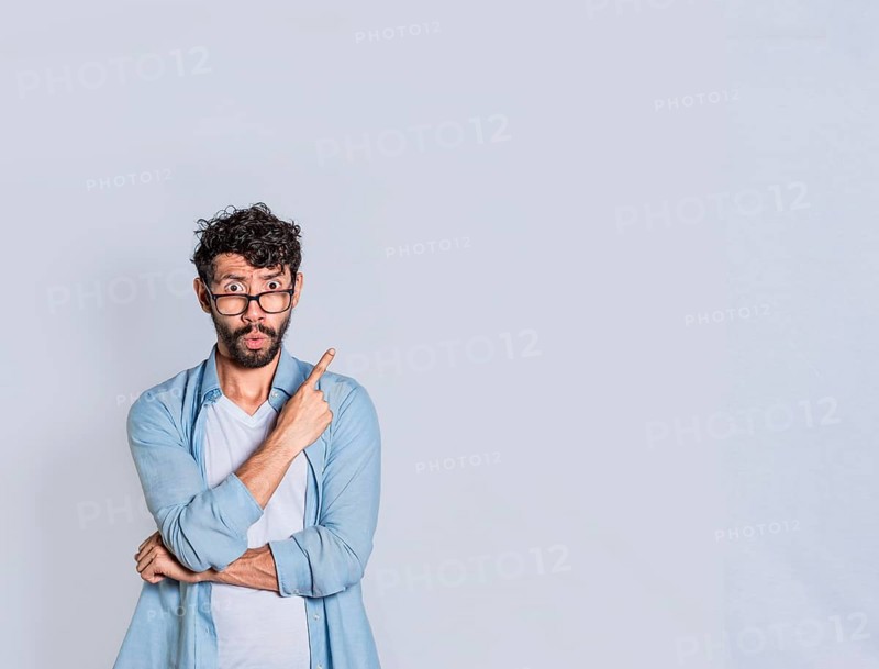 Surprised person pointing an advertisement to the right, Amazed handsome man pointing his finger to the right
