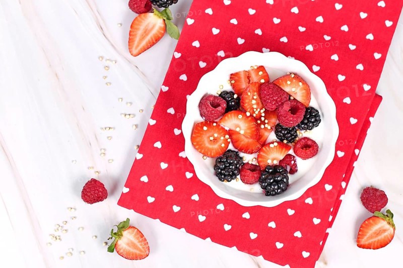Top view of berry mix yogurt bowl with strawberry, raspberry and blackberry fruits and puffed quinoa