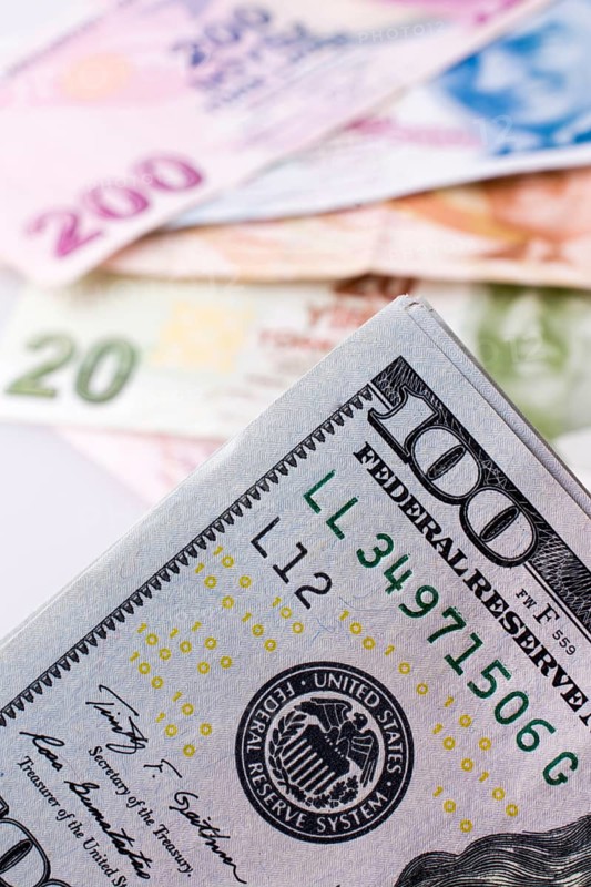 American dollar banknotes and Turksh Lira banknotes side by side on white background,