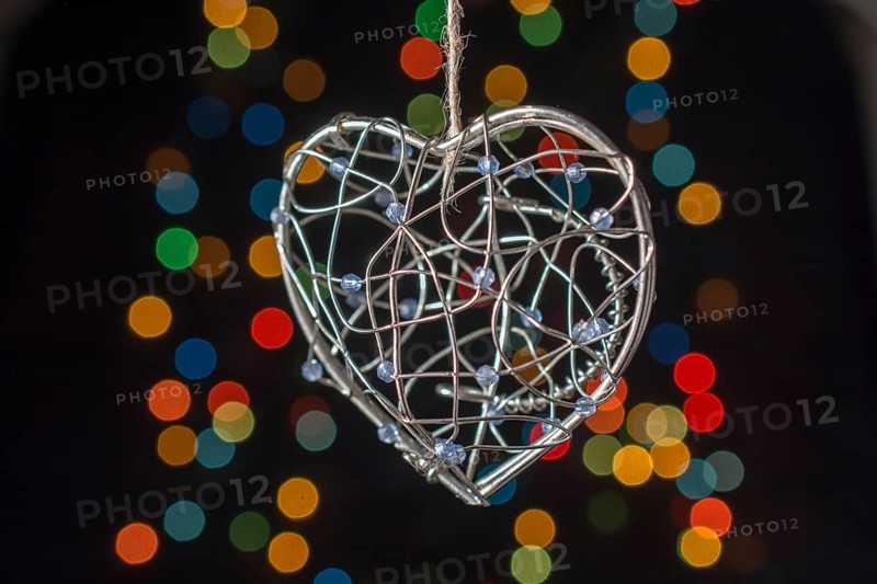 Heart shaped metal cage on a bokeh light background,