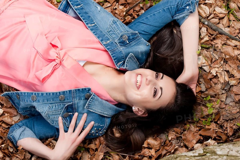 Young woman lying on the forest floor,