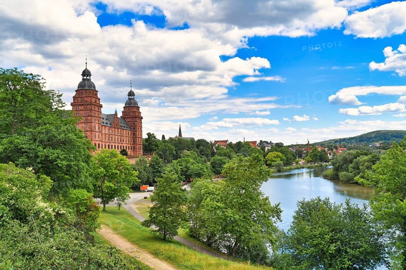 Beautiful view over German city Aschaffenburg with Main river, palace called Schloss Johannisburg and green park on sunny summer day