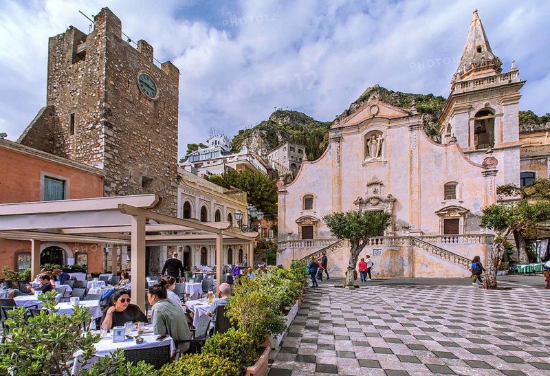Belvedere Piazza IX Aprile with street cafe, clock tower and church of San Giuseppe