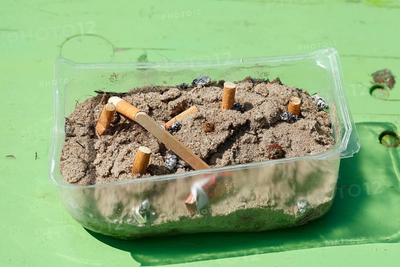 Cigarette butts in a plastic bowl as an ashtray, Germany
