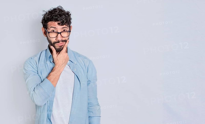 Handsome man rubbing his beard with a doubtful expression, Person rubbing his chin with a doubtful expression. handsome bearded man with doubt expression isolated