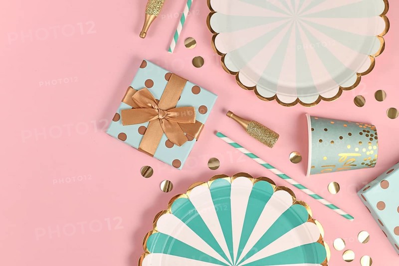 Party flat lay with teal blue paper plates, gift box