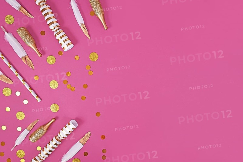 Party flat lay with golden and white decoration like confetti and feathers on pink background with copy space,