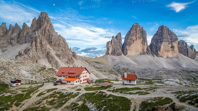 View of mountain hut Dreizinnenhuette and chapel with rock massif Paternkofel and mountain range drei Zinnen, panorama